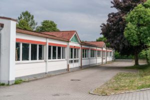 Gebäude Westseite - Blick nach Süden, PKW Stellplätze