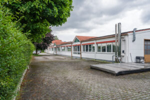Gebäude Westseite - Blick nach Norden, Hackschnitzelbunker, PKW Stellplätze